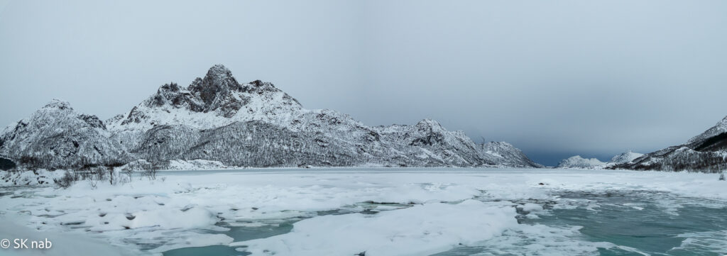 Eisschollen und schneebedeckte Bergkuppen auf den Vesterålen
